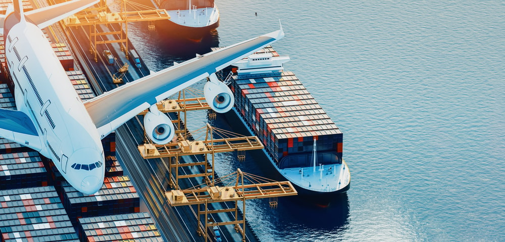 airplane flying over boats loaded with cargo