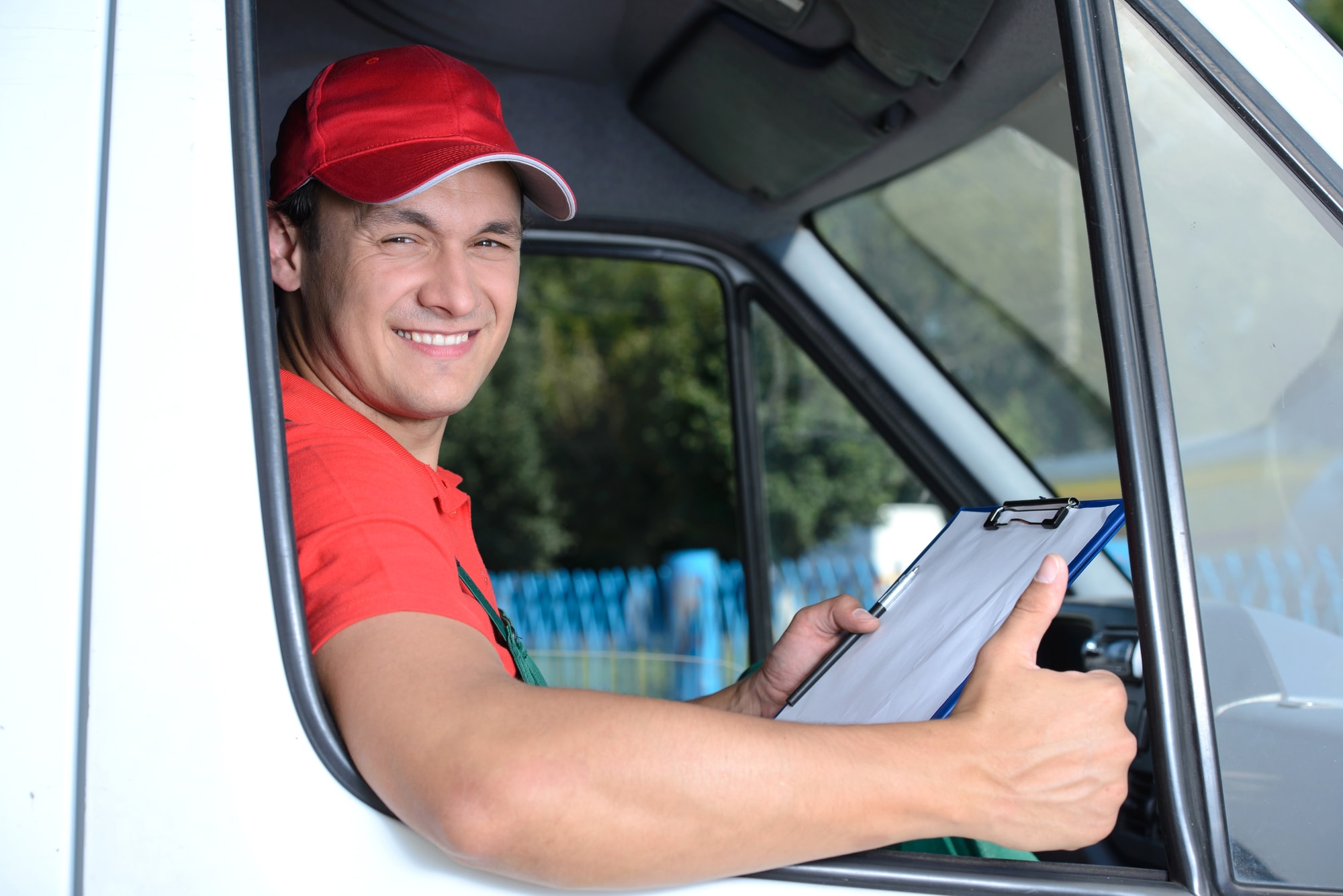 Delivery driver giving thumbs up in truck window. 