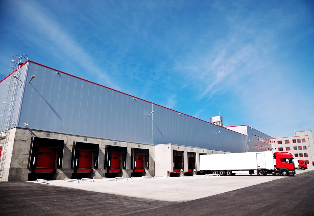 A semi truck backed into a loading dock at a warehouse