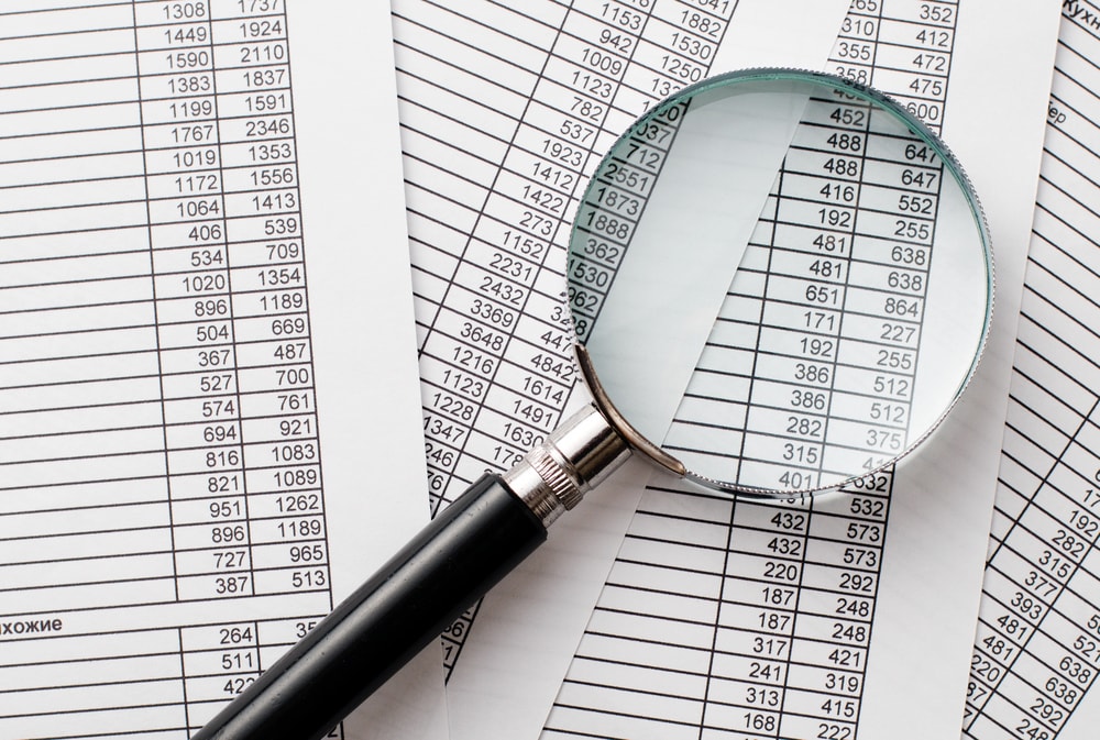 Magnifying glass over numbers on paper