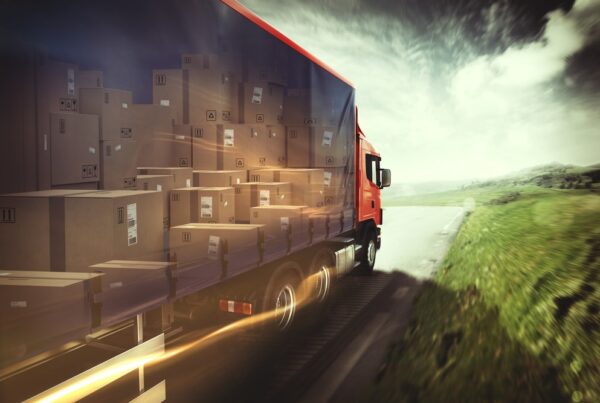 Truck with boxes in trailer driving down a road