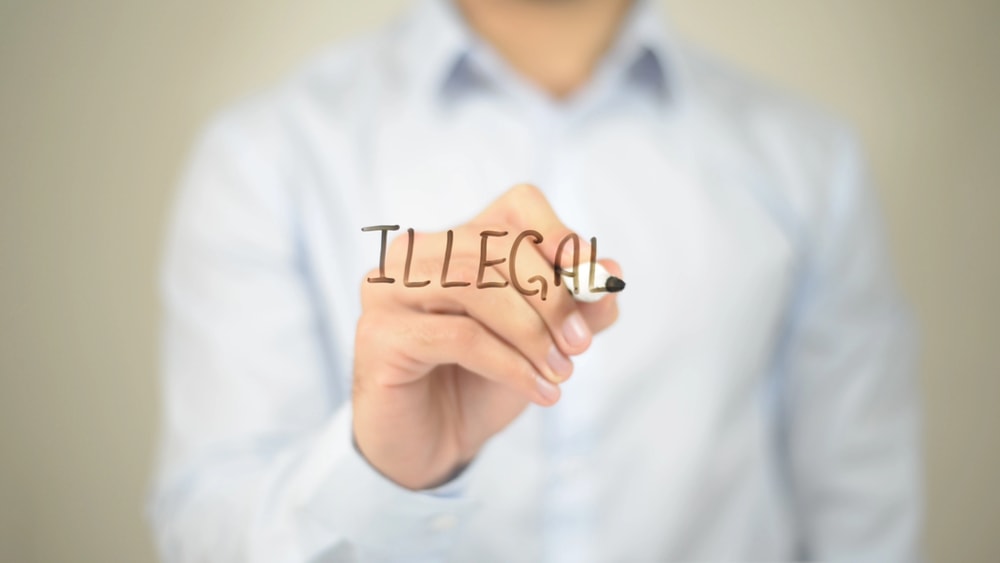 Man writing the word illegal