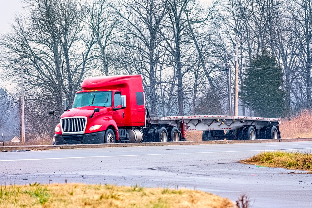 flatbed trailer with red truck