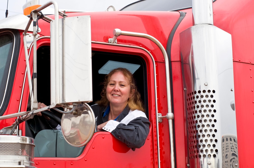 female truck driver smiling in cab