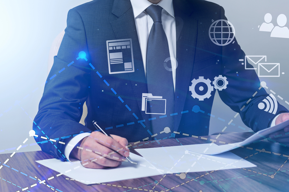 man in suit writing on paper with icon overlays